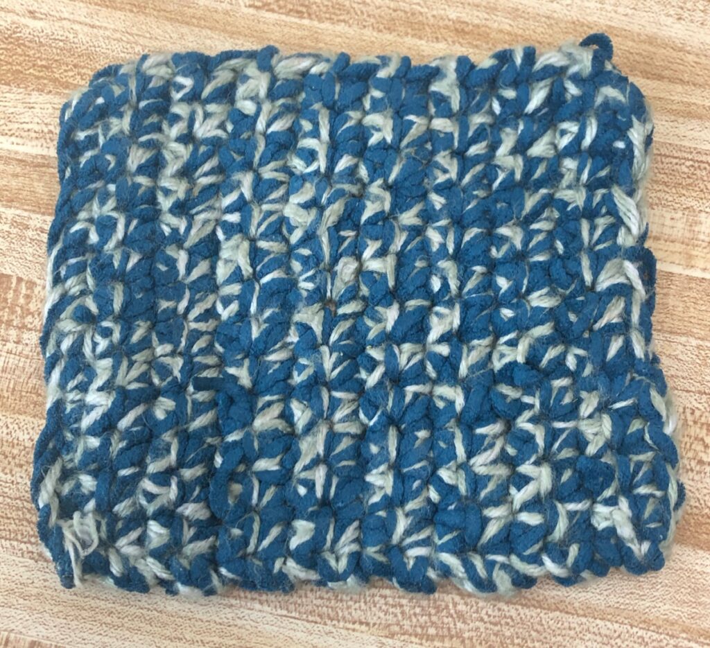 crocheted hot pad with green and blue yarn