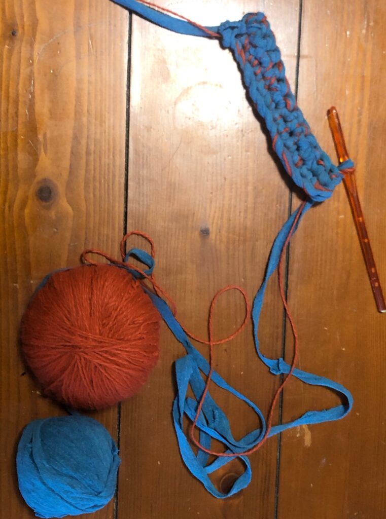 orange and teal colored yarn hook one row of single crochet started