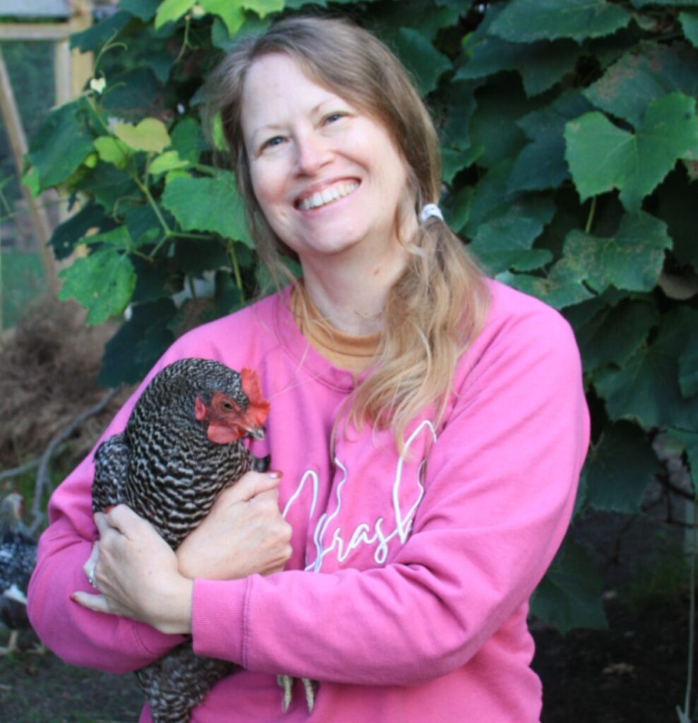 female holding chicken and smiling