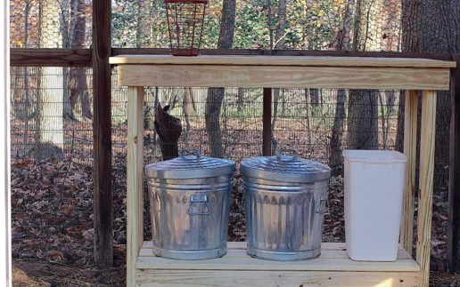 chicken supplies in metal cans on a storage shelf outside
