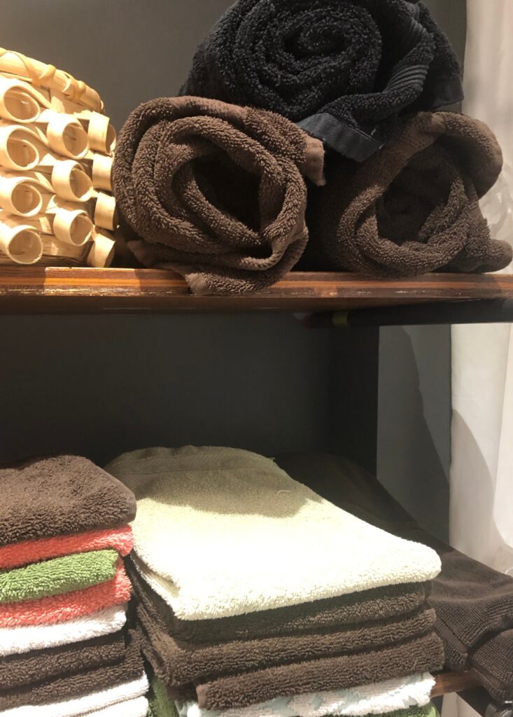 towels and basket on shelves in bathroom