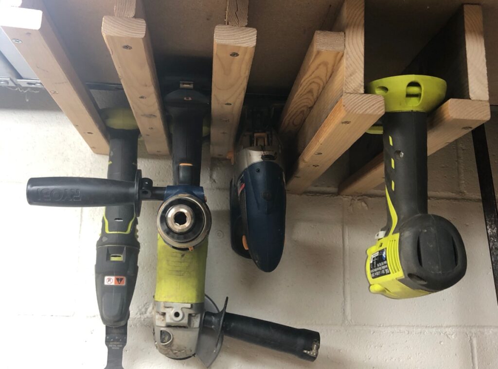 Power tool organizing station connected to an upper shelf made out of scrap wood